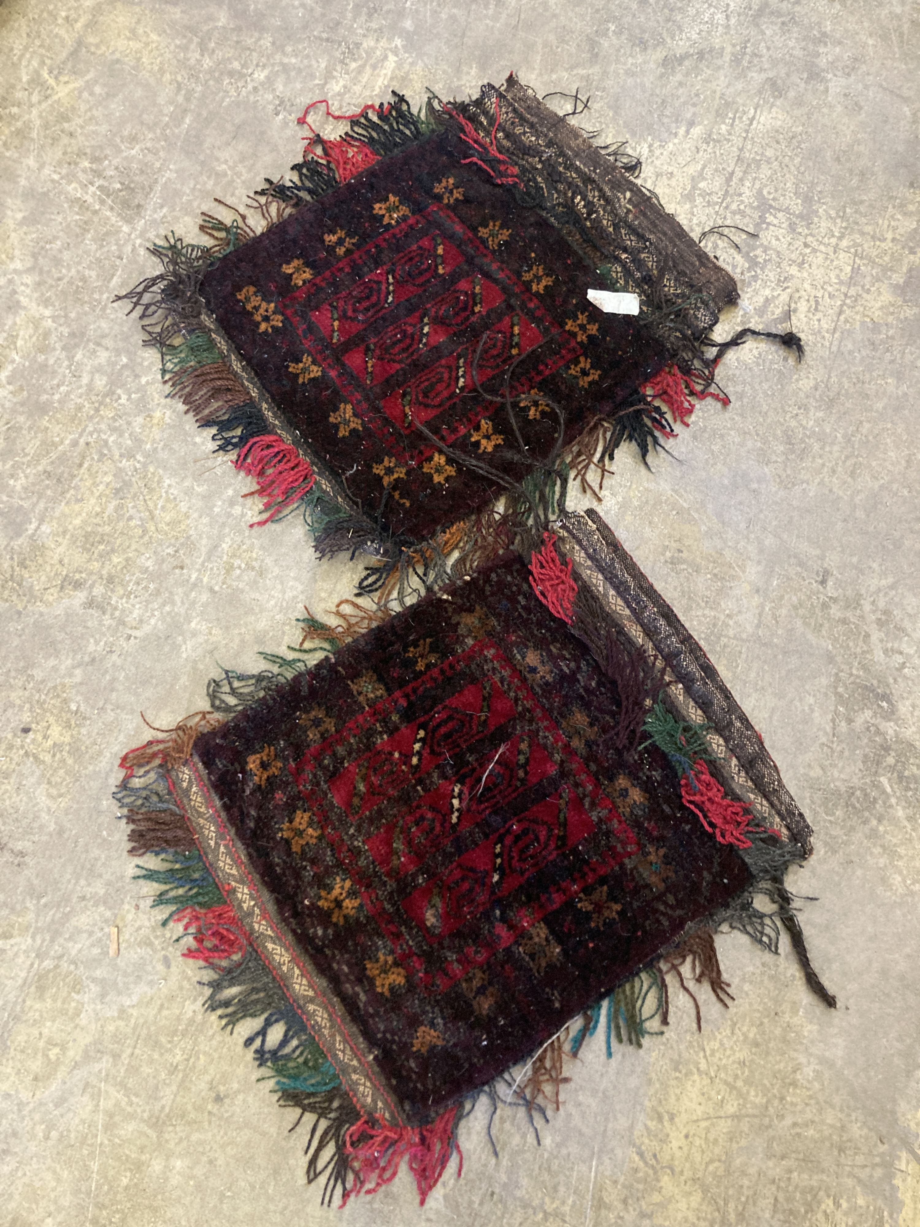 An Afghan red ground rug with stylised mihrab and iris motifs, a small Afghan rug and three carpet panel cushion covers, largest 200 x